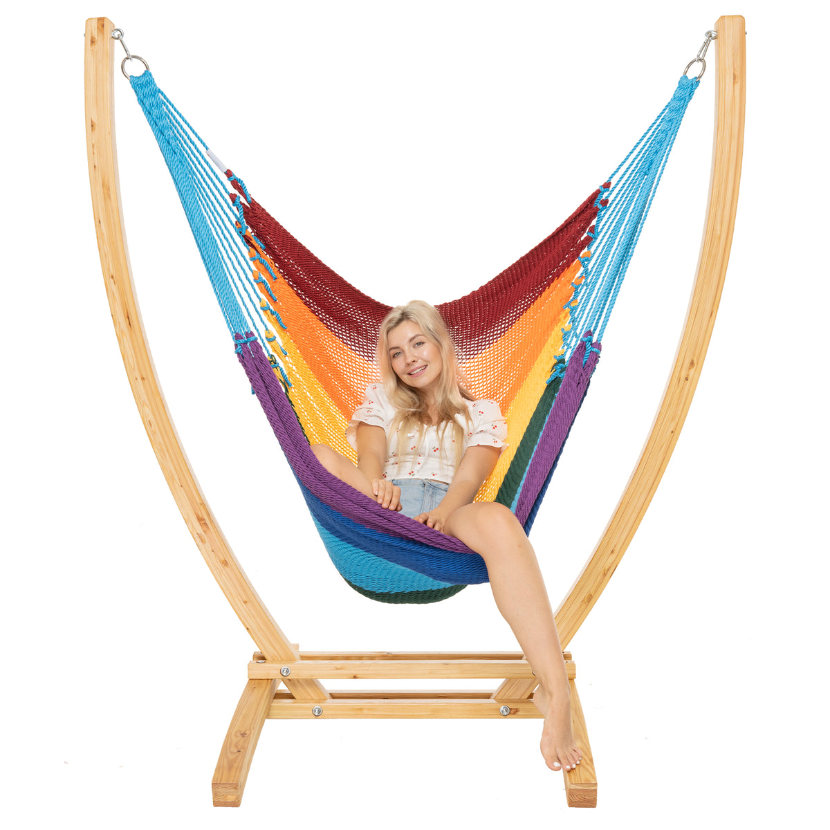 Rainbow Jumbo Caribbean Recliner on a Siberian larch wood arc stand, woman seated upright, front view