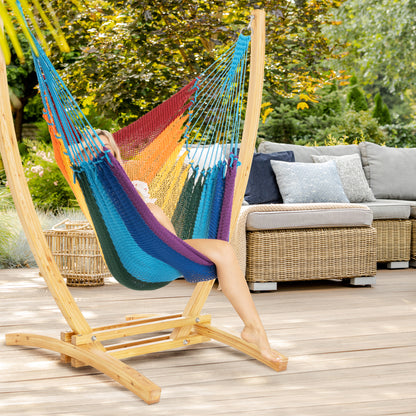 Rainbow Jumbo Caribbean Recliner on a wood arc stand on a deck beside a wicker sofa