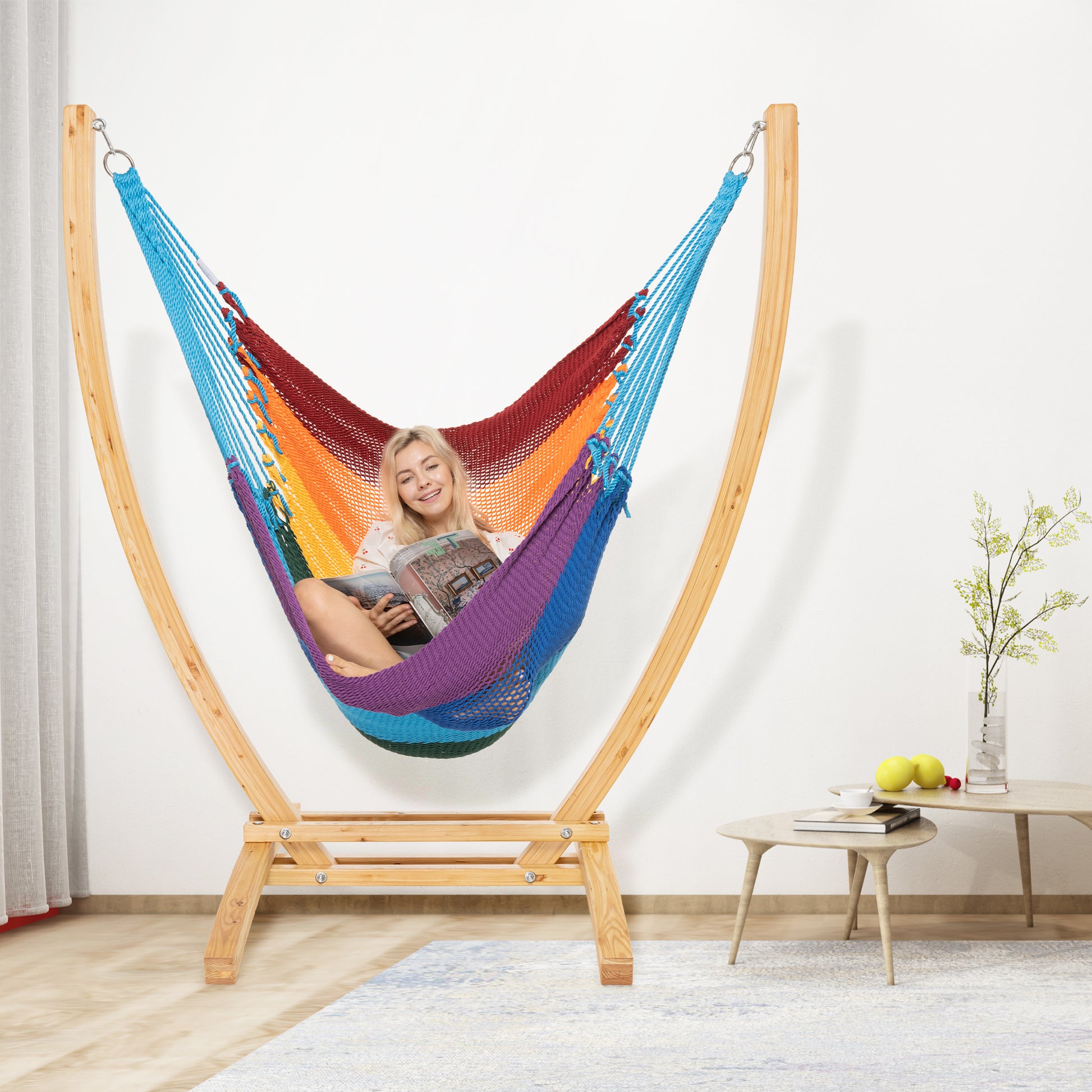 Rainbow Jumbo Caribbean Recliner on a wood arc stand in a living room beside a low round side table