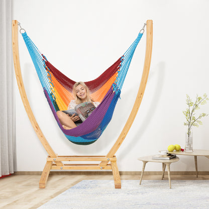Rainbow Jumbo Caribbean Recliner on a wood arc stand in a living room beside a low round side table