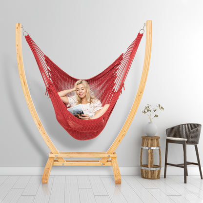 Red Jumbo Caribbean Recliner on a wood arc stand in a styled interior corner beside a woven barstool