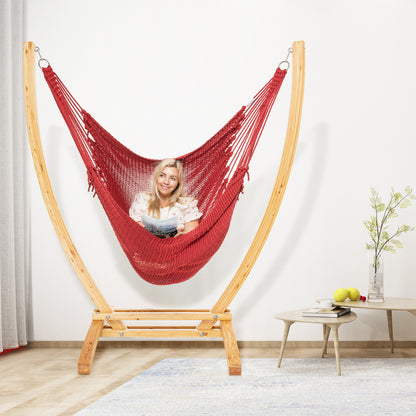 Red Jumbo Caribbean Recliner on a wood arc stand in a living room beside a low round side table