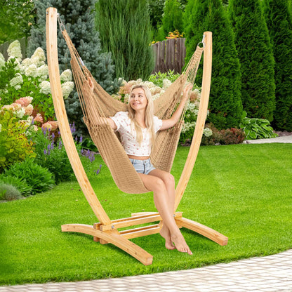 Tan Jumbo Caribbean Recliner on a wood arc stand in a backyard beside flowering hydrangeas