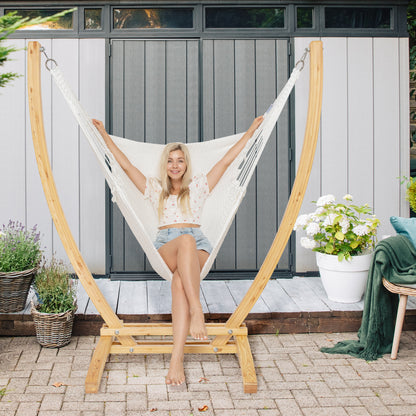 White Jumbo Caribbean Recliner on a wood arc stand on a brick paver patio in front of a grey garden shed