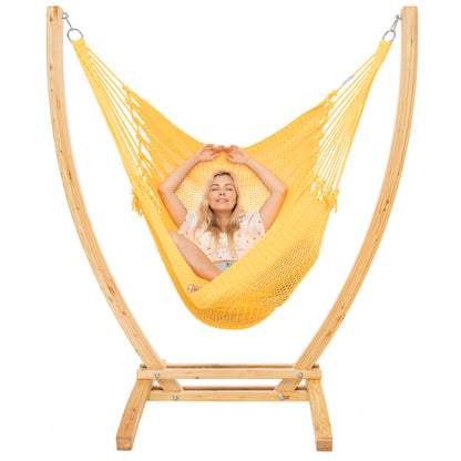 Yellow Jumbo Caribbean Recliner on a Siberian larch wood arc stand, woman leaning back with hands behind the head