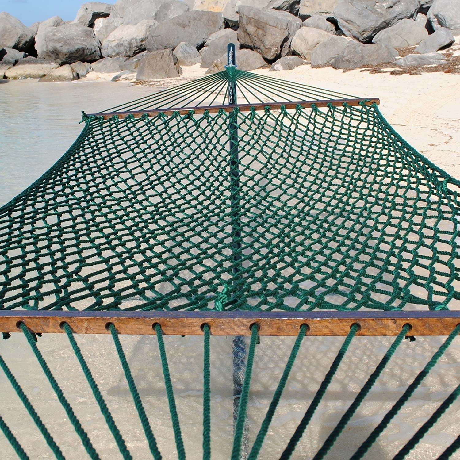 Green Jumbo Rope Hammock on a black Tri-Beam hammock stand at the water's edge.