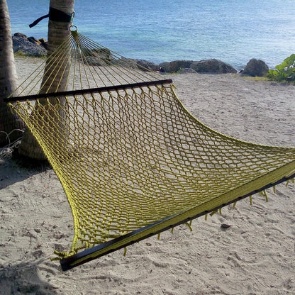 Olive Jumbo Rope Hammock strung from a palm tree on a sandy Caribbean beach.