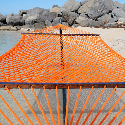 Orange Jumbo Rope Hammock on a black Tri-Beam hammock stand at the water's edge.