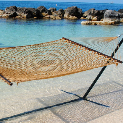 Tan Jumbo Rope Hammock on a black Tri-Beam hammock stand at the water's edge.