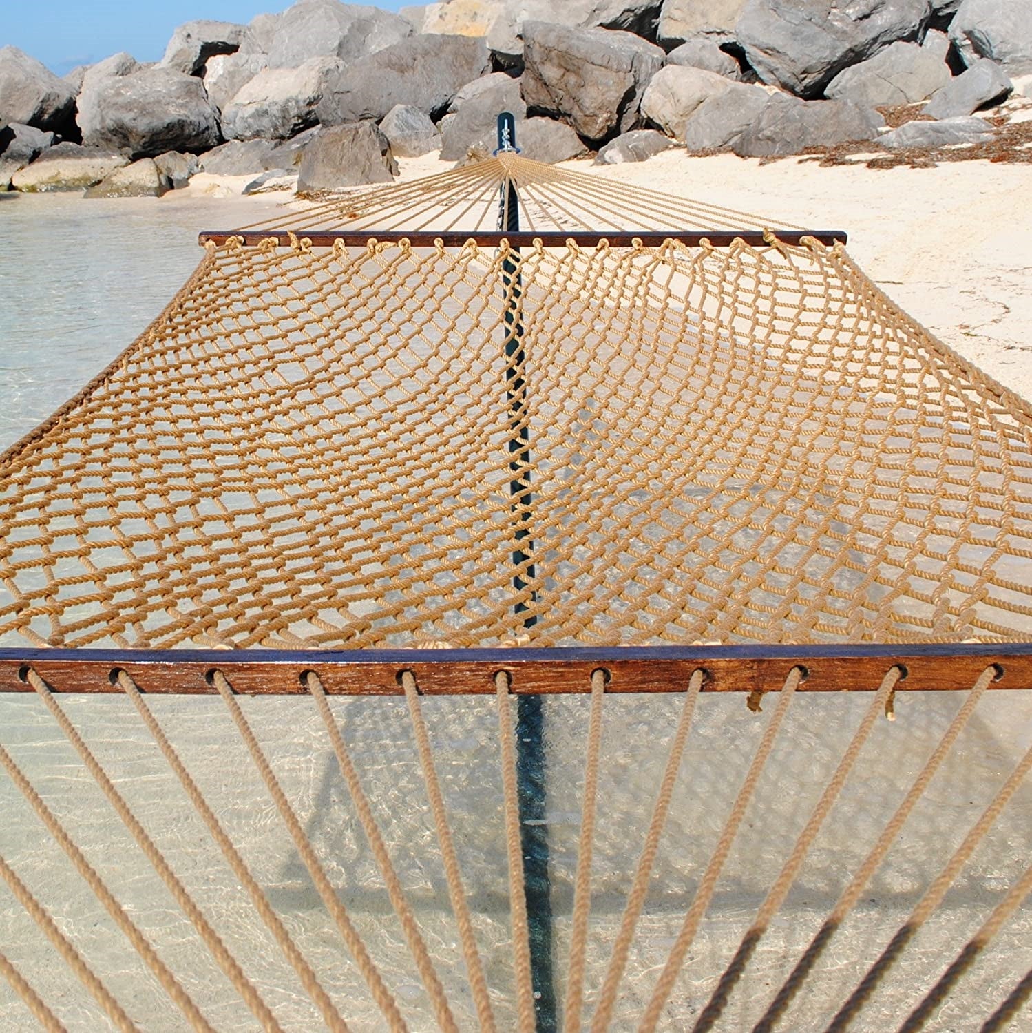 Tan Jumbo Rope Hammock on a black Tri-Beam hammock stand at the water's edge.