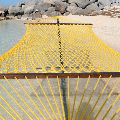 Yellow Jumbo Rope Hammock on a black Tri-Beam hammock stand at the water's edge.