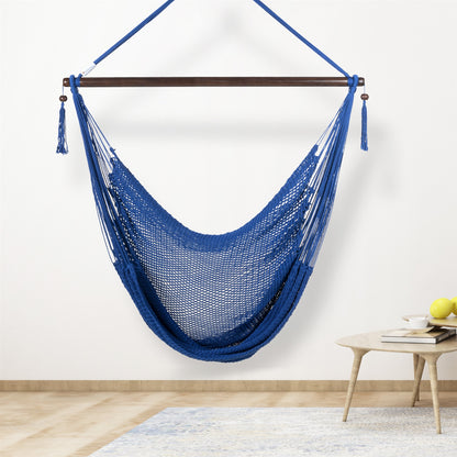 Dark blue Large Caribbean Hammock Chair hanging indoors beside a small round side table against a cream wall