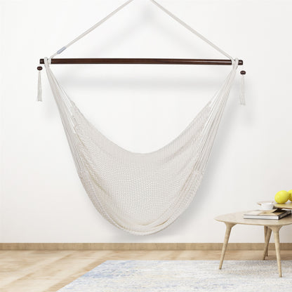 White Large Caribbean Hammock Chair hanging indoors beside a small round side table against a cream wall